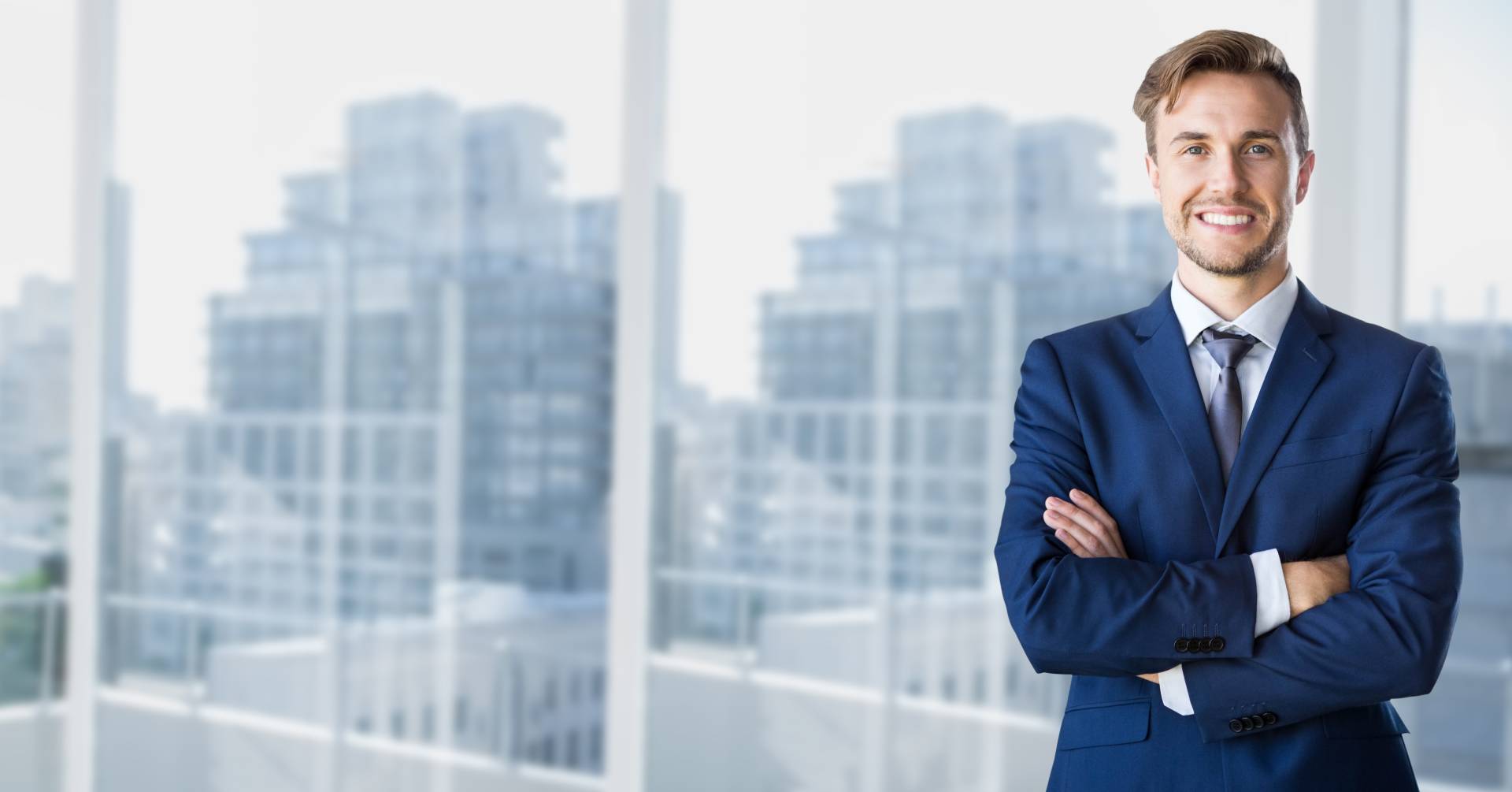 Smiling businessman in suit with arms crossed